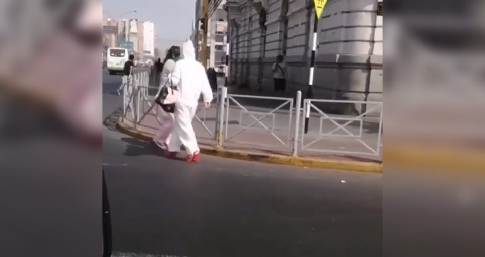 El impensado look de una mujer en cuarentena: traje de bioseguridad y zapatos rojos