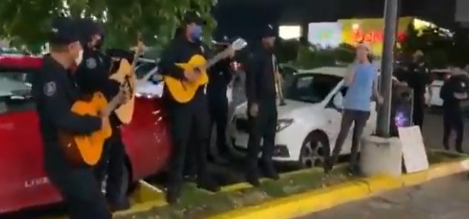 Cantaba para juntar monedas en un estacionamiento y recibió la compañía de una banda de “policías mariachis”