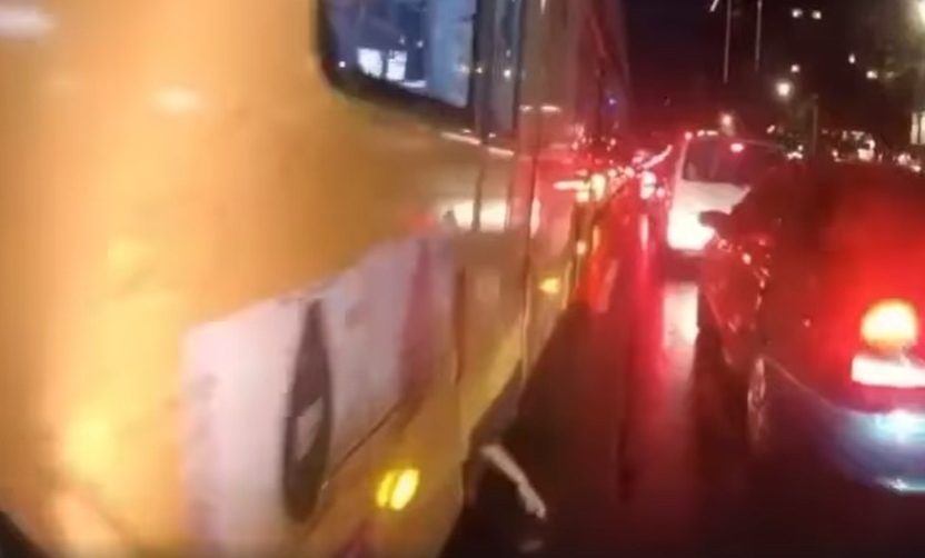Un motociclista logró captar el momento en el que un brazo colgaba de la puerta de un colectivo